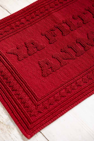 A detail image showing the raised border and text on the Filthy Animal Cherry Red Bath Mat. 