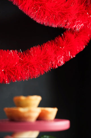 The Bright Red Tinsel styled with some mince pies in the background.