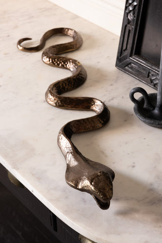 The Bronze Cobra Snake Ornament shown on a marble surface. 