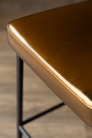 Close-up image of the Burnished Gold Roll Back Bar Stool showing the stitching