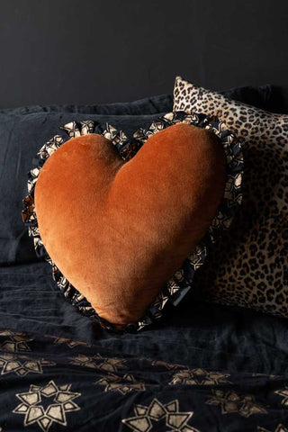 Lifestyle image of the Burnt Orange Velvet Ruffle Heart Cushion