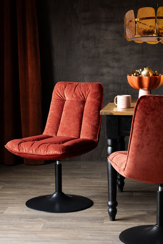 Two Burnt Orange Velvet Swivel Dining Chairs styled with a dining table.