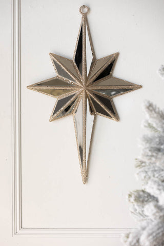 Lifestyle image of the Champagne Gold Mirrored Star Wall Decoration