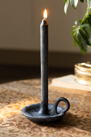 The Charcoal Dinner Candle & Wax Candle Plate shown lit on a leopard coffee table with a plant in the corner. 