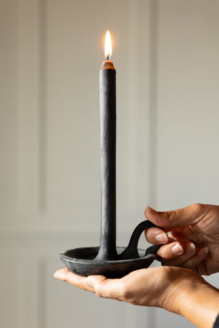 The Charcoal Dinner Candle & Wax Candle Plate shown lit while being held. 