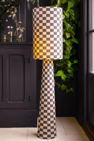 Image of the Charcoal & Natural Checkerboard Floor Lamp turned on so that the light glows through the fabric