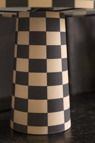 Close up image of the base of the checkerboard light against a dark background