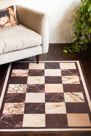 Image of Checkered Burgundy Marble Effect Durable Floor Mat under a beige armchair. 