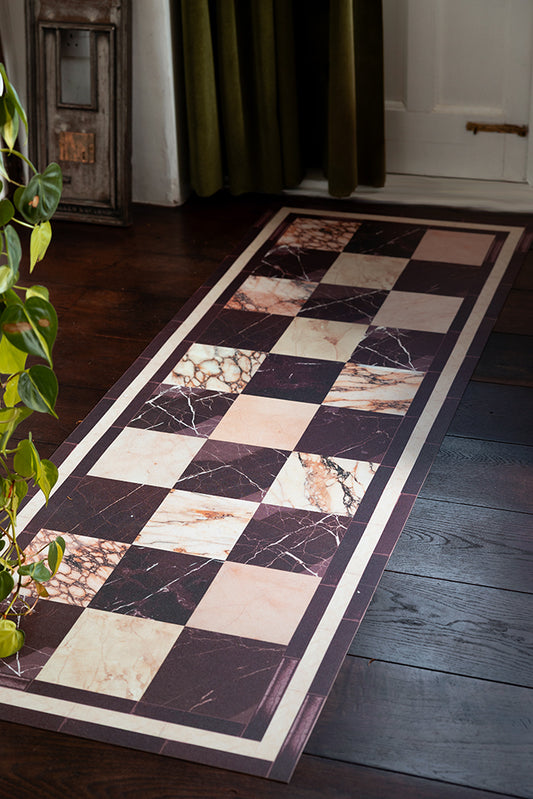 Image of the Checkered Burgundy Marble Effect Durable Runner in a hallway against dark wood floors. 