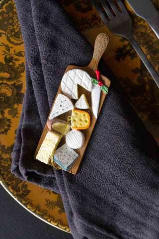 The Cheese Board Christmas Decoration shown on a floral plate against a grey napkin. 