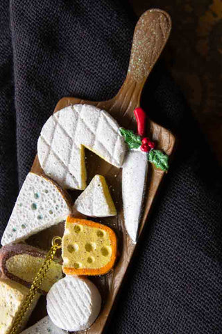 A detail of the The Cheese Board Christmas Decoration, shown against a grey napkin.