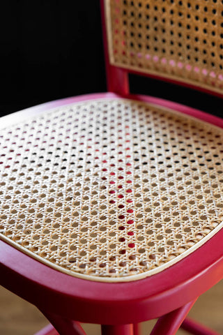 Close-up of the seat of the Chez Pitou Wood & Woven Cane Bar Stool in Red.