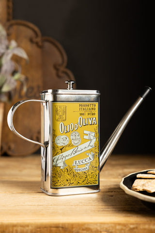 The Classic Stainless Steel Olive Oil Dispenser styled with other dining accessories.