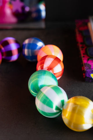 Close-up of the Colourful Thread Bauble Christmas Garland on a dark surface.