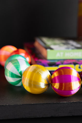Close-up of the Colourful Thread Bauble Christmas Garland on a dark surface.