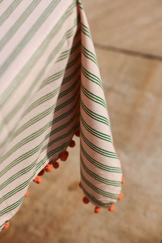 Image of the pom poms on the Cotton Green Stripe Table Cloth with Orange Pom-Poms