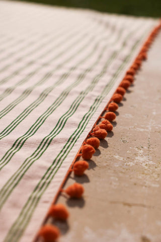 Image of the Cotton Green Stripe Table Cloth with Orange Pom-Poms