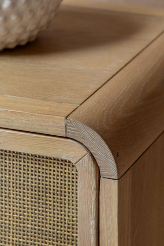 Close-up of the corner of the Curved Wood & Rattan Chest Of Drawers.