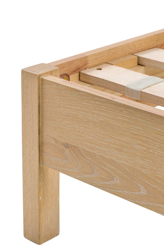 Close-up of the frame of the Curved Wood & Rattan Bed on a white background.