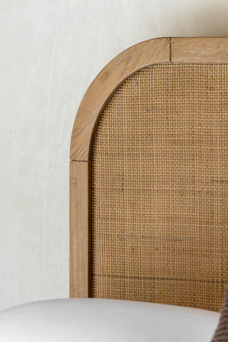 Close-up of the headboard of the Curved Wood & Rattan Bed.