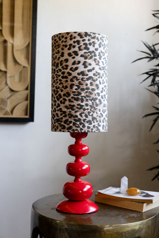 Curve Red Table Lamp With Leopard Shade shown with the light off and styled on a gold side table against neutral wall. 