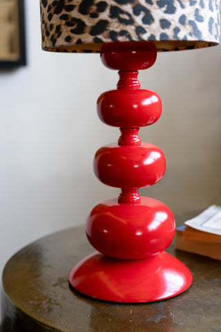 Detail of the red curve bobbin base of the Curve Red Table Lamp With Leopard Shade. 