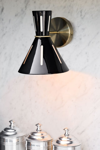Lifestyle image of the Cut Out Wall Light illuminated and displayed on a kitchen wall. 