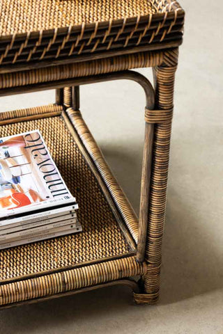 Close-up image of the Dark Brown Rattan Side Table with magazines displayed on the lower tier.