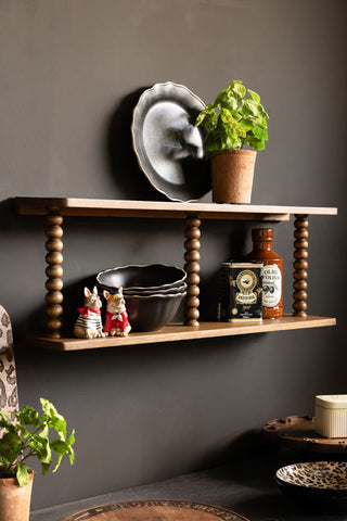 The Dark Wood Bobbin 2-Tier Wall Shelf styled in a kitchen with plates, plants and accessories. 