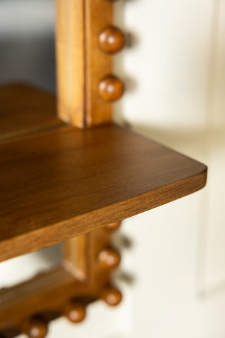 The corner of the shelf on the Dark Wood Bobbin Mirror With Shelf. 