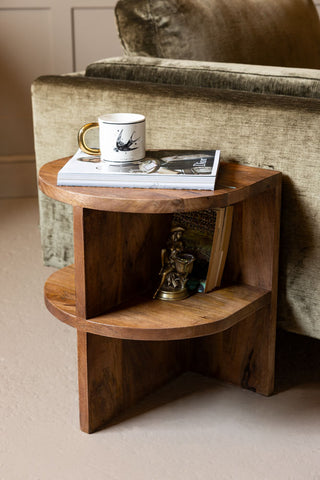 The Dark Wood Shelf Side Table shown against a green velvet sofa in a living room