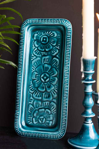 The Deep Blue Enamel Cast Style Trinket Tray displayed on a black background, styled with blue candles sticks
