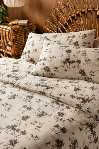Close up of the Desert Island Cotton Muslin Bedding Set, styled against a rattan bed frame