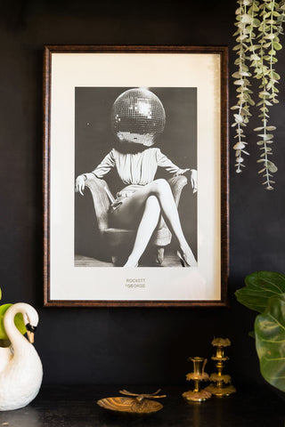 The Disco State Of Mind Wall Art shown on a black wall with gold accessories in the background. 