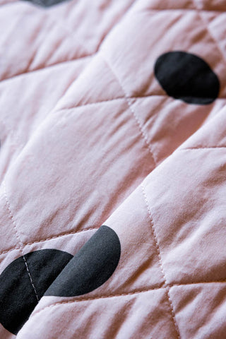 A close up of the Dot Noir Ruffled  Bedspread, showing the quilted detailing. 