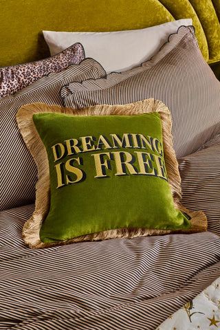 Lifestyle image of the Dreaming Is Free Velvet Fringe Feather Filled Cushion on a bed