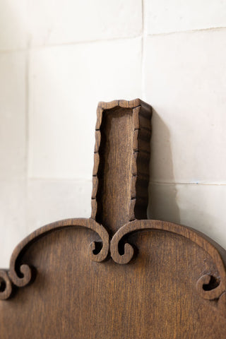 The handle and top of the Edibles Scalloped Wooden Serving Board. 