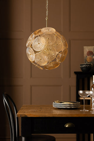 The Elegant Frosted Amber Leaf Ceiling Light hanging above a dining table.
