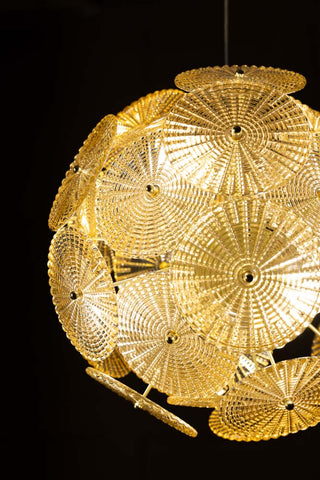 The Elegant Frosted Amber Leaf Ceiling Light switched on in front of a black background.