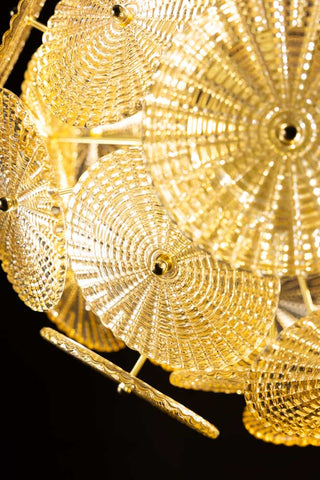 Close-up of the design of the Elegant Frosted Amber Leaf Ceiling Light, switched on in front of a dark background.