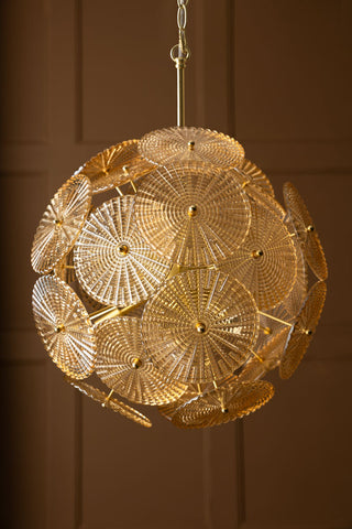 The Elegant Frosted Amber Leaf Ceiling Light hanging in front of a panelled wall.