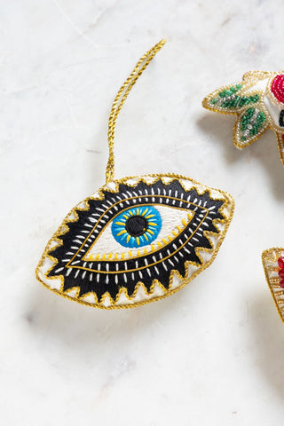 The Embroidered Blue Eye Hanging Christmas Tree Decoration styled with others on a white surface.