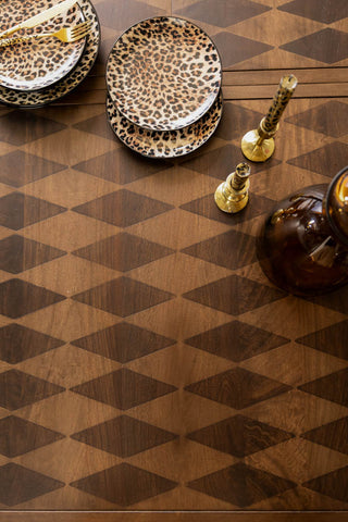 The Emporium Brick Red Extendable Dining Table  shown from above with leopard print plates and gold candlesticks. 