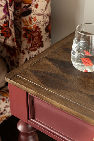 The side of the Emporium Brick Red Side Table, showing the harlequin detail on the wood. 