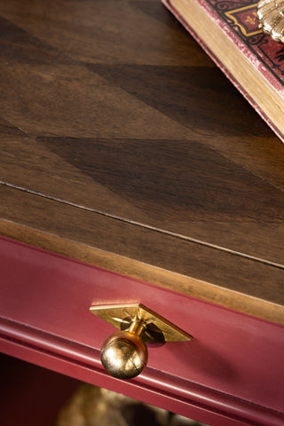 Detail of the harlequin wood top and the gold handle on the Emporium Brick Red Side Table. 