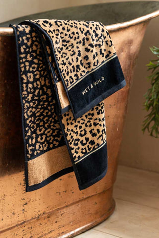 Image of the Wet & Wild Leopard Print Hand Towel shown against a copper bath.