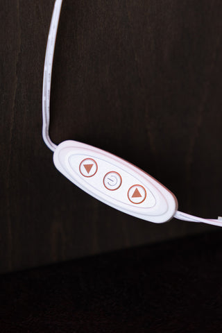 Control panel with buttons on a wire, on a dark background.