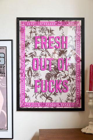 Lifestyle image of the Fresh Outta Fucks A2 Art Print in a black frame on a light background