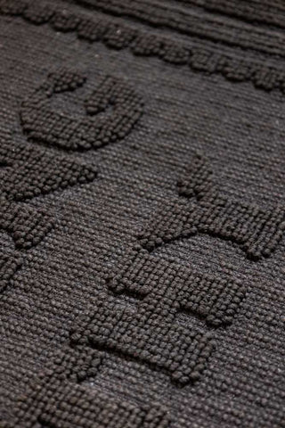 Close-up of the text on a black bath mat.
