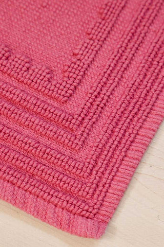 The corner of the Fucking Filthy Hot Pink Bath Mat 